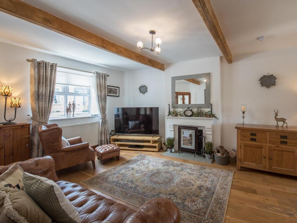 un soggiorno con divano e TV di Harpers Cottage a Barrowford