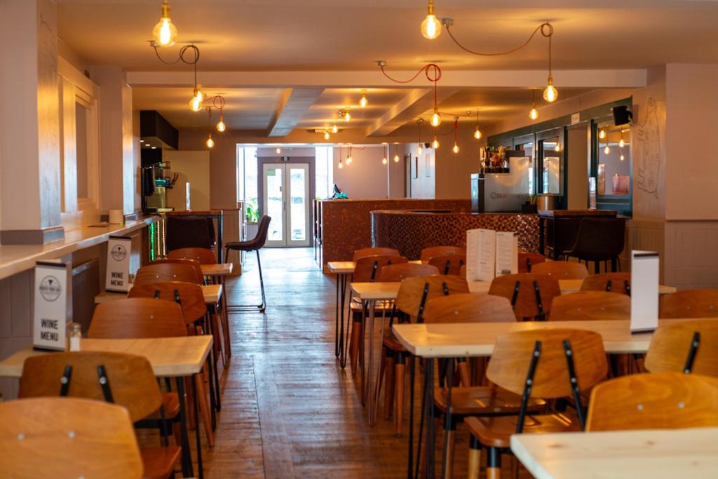 Hampton Hotel & restaurant في لاندرندود ويلز: مطعم بطاولات وكراسي خشبية في الغرفة