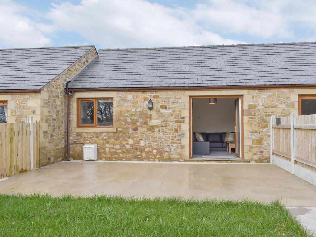 a stone house with a patio in front of it at Seven Dorchester Drive - Uk32625 in Inglewhite