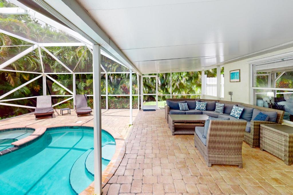 a patio with a pool and a couch and a table at Eastwood Hideaway in Fort Pierce