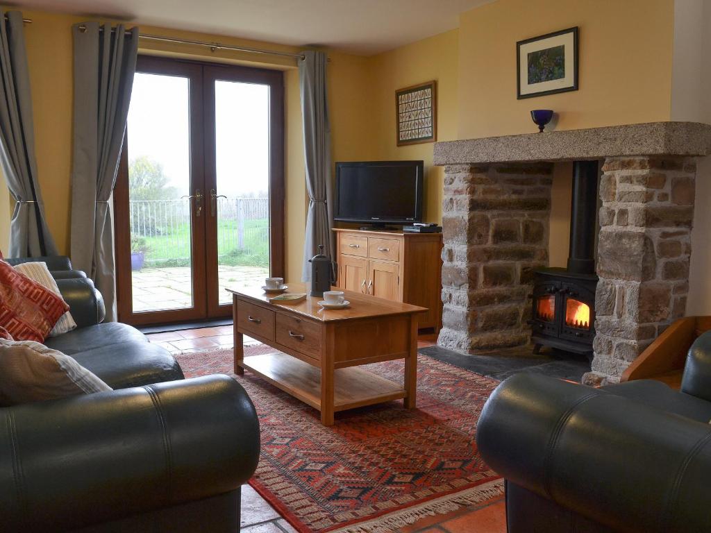 a living room with a couch and a fireplace at Orchard Cottage - Ukc4300 in Littleham