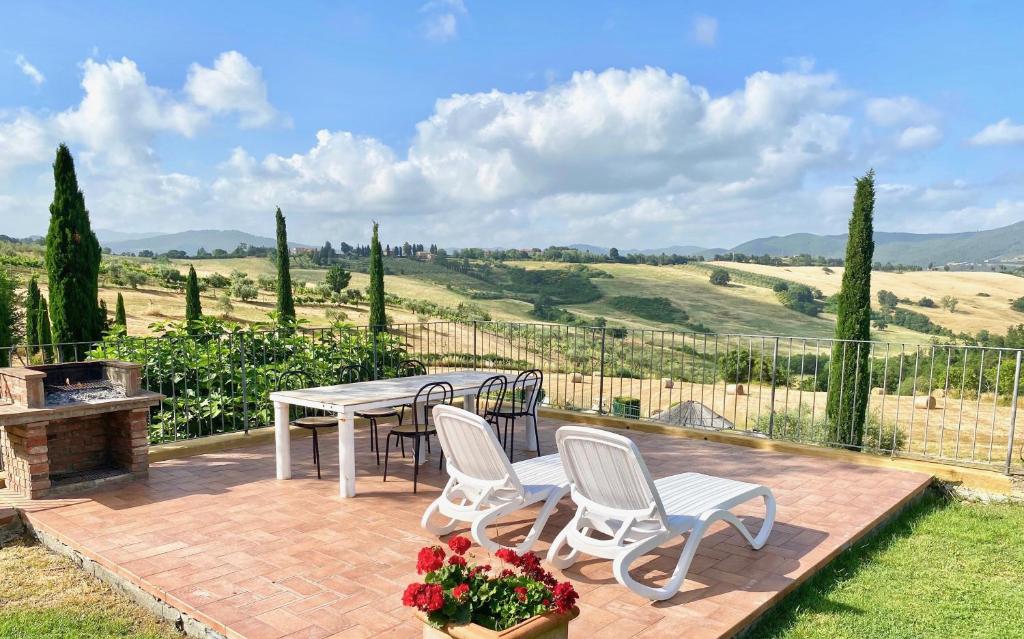a patio with a table and chairs and a fence at Agriturismo San Tommaso in Pomarance