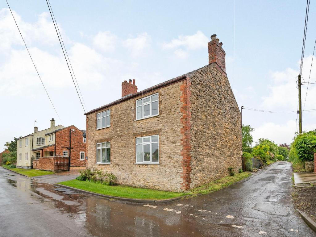 an old brick house on the side of a street at Stonegarth in Snitterby