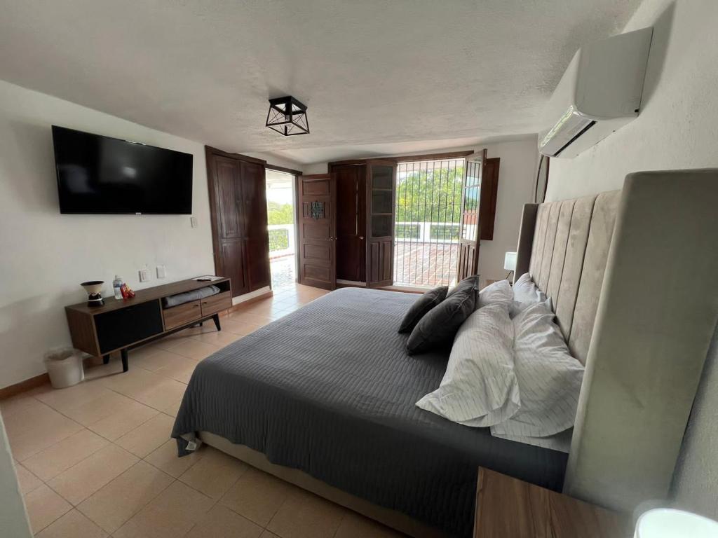 a bedroom with a bed with pillows and a television at Casa Praxedis in Santiago