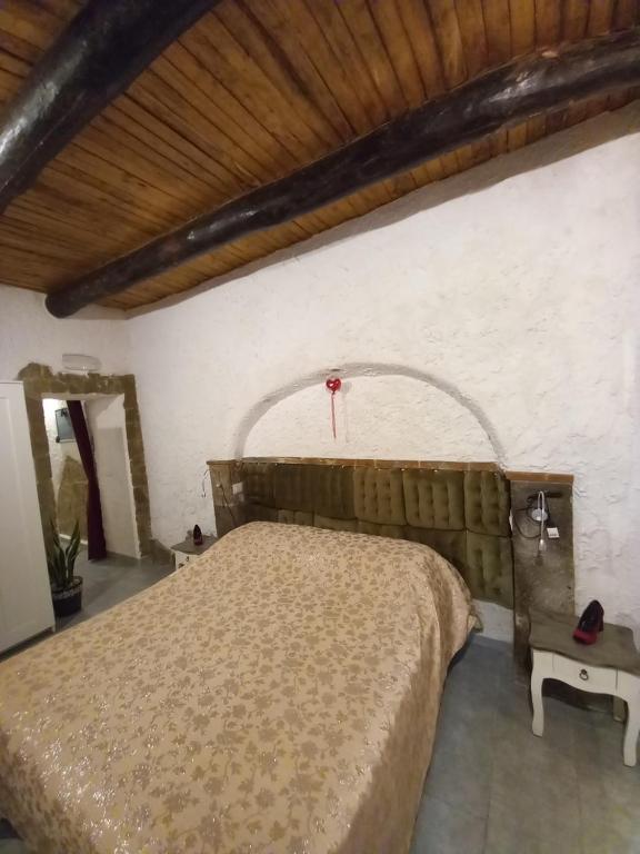 una camera con letto e soffitto in legno di La Grotta a Napoli