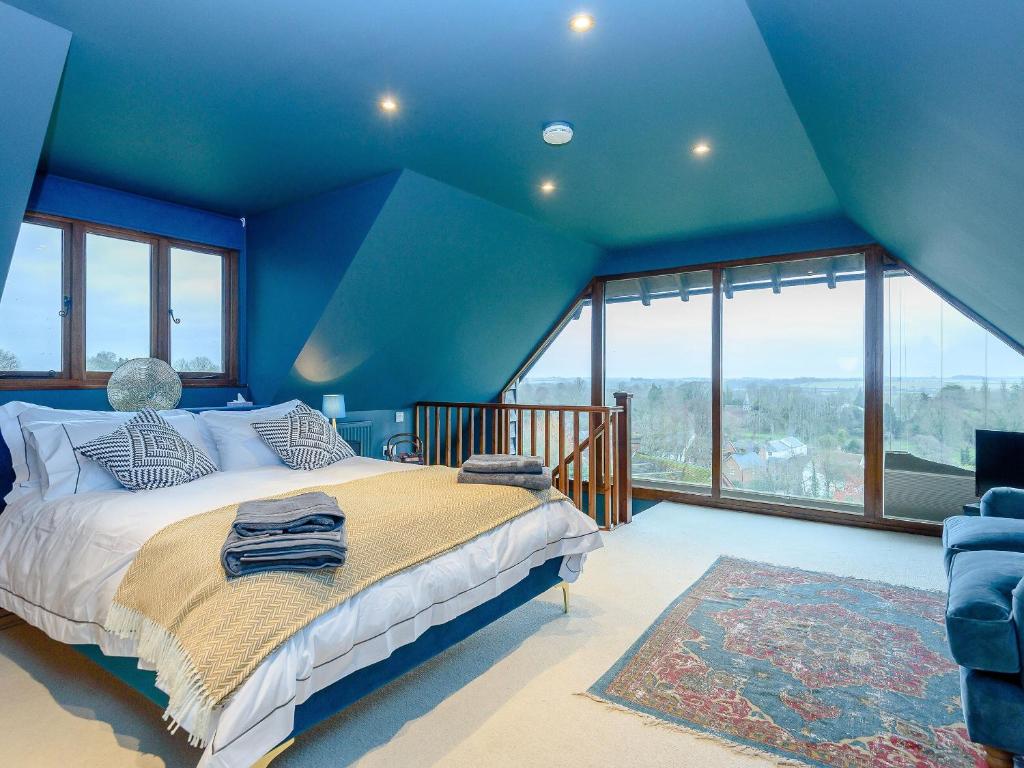 niebieska sypialnia z łóżkiem i niebieskim sufitem w obiekcie River Test View w mieście Chilbolton