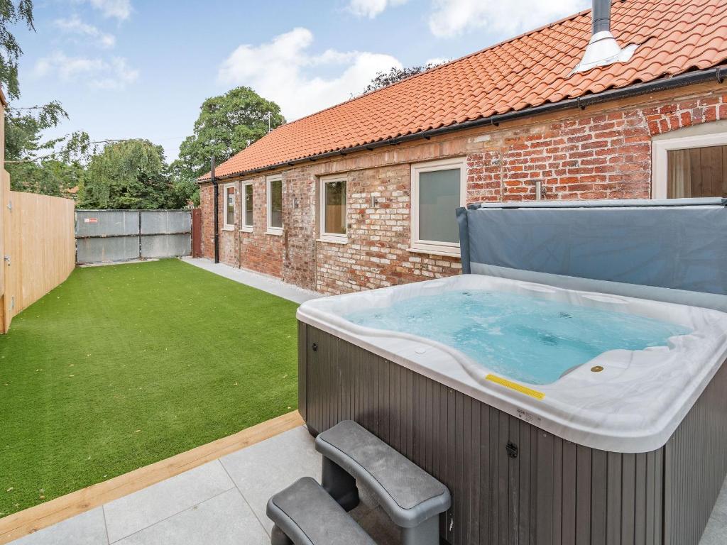 a hot tub in the backyard of a house at Cattle Crush Cottage - Uk35988 in Great Driffield