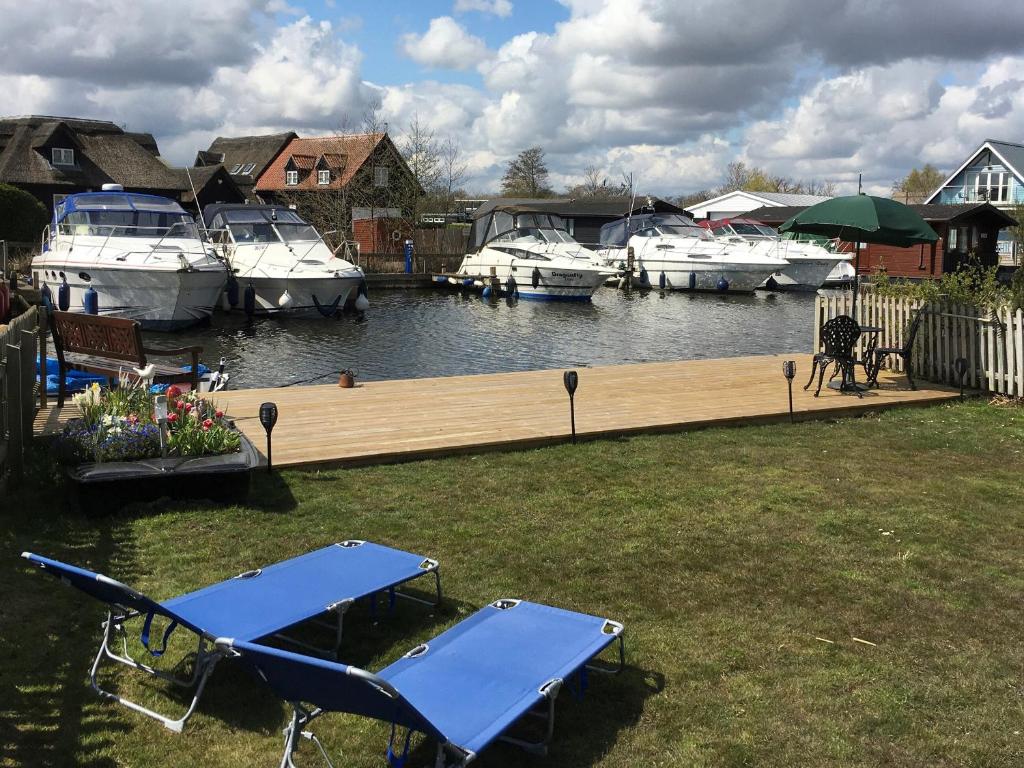 ein blauer Picknicktisch und Boote in einem Yachthafen in der Unterkunft Bullrushes in Horning