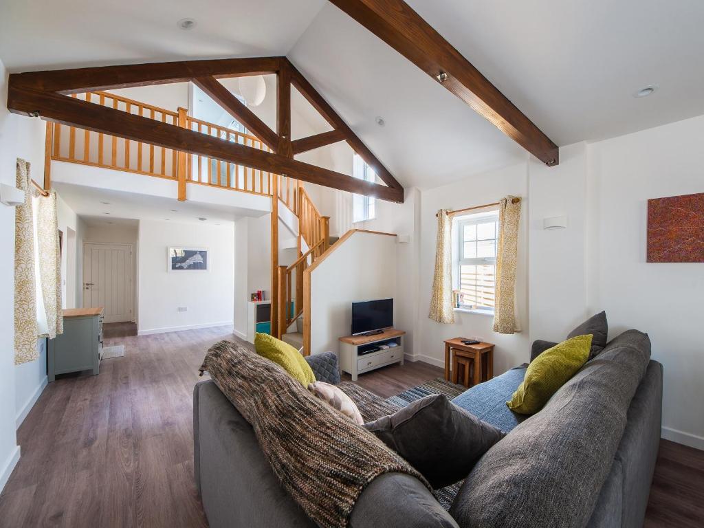 een woonkamer met een bank en een tv bij Beech Cottage - Uk11845 in Saltash