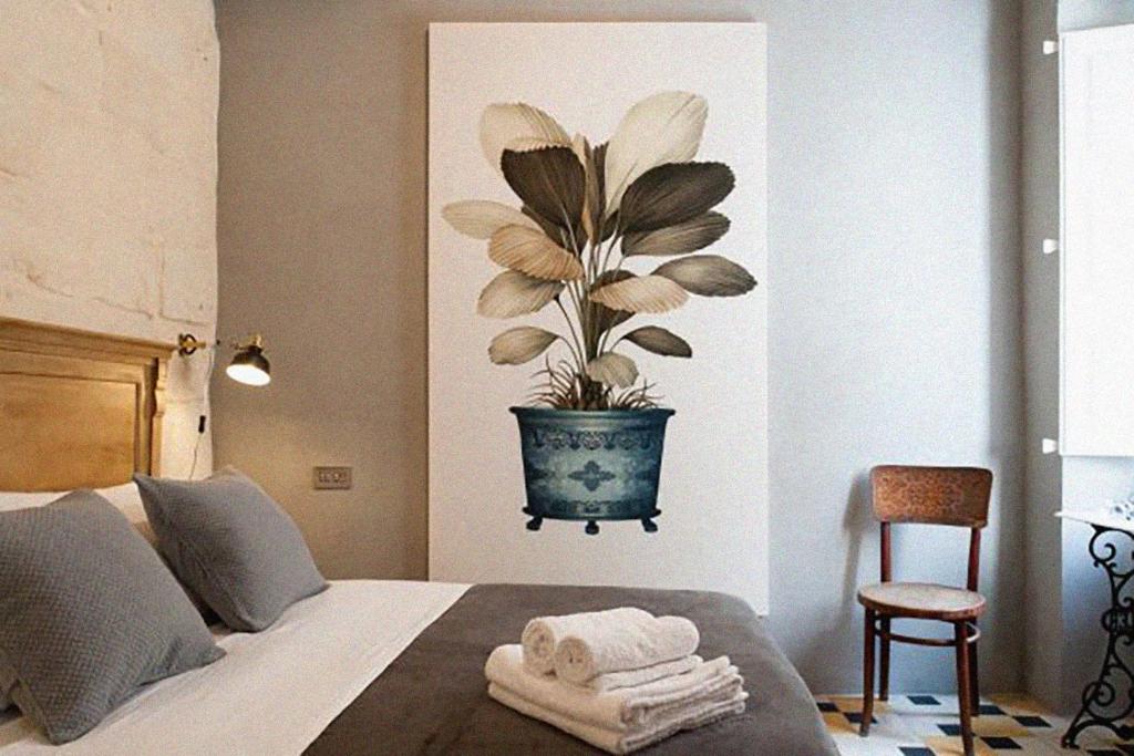 a bedroom with a potted plant on the wall at Dar Isla, in the heart of the Three Cities, Malta in Senglea