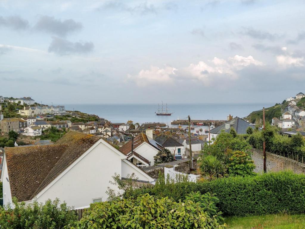 a view of a town with a ship in the ocean at Penfose Apartment in Mevagissey