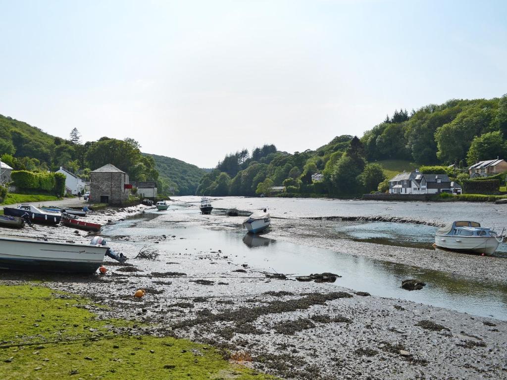 a river with boats sitting on the shore at Watercolour Cottage in Lerryn