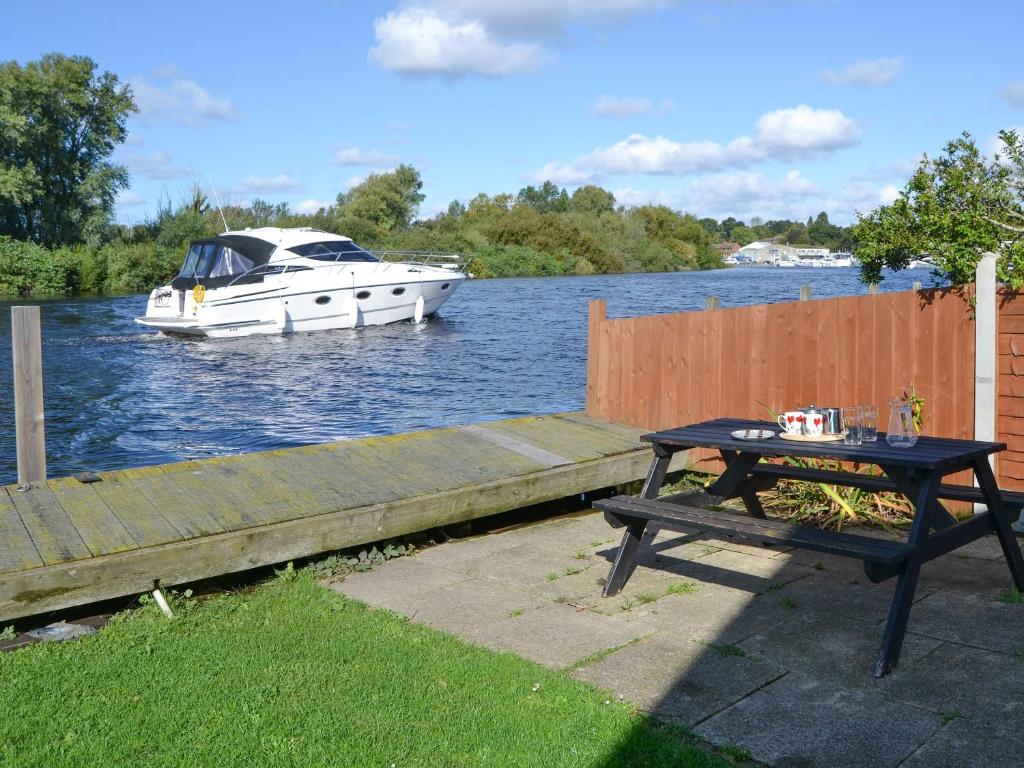 a boat in the water with a table and a boat at Pintail in Brundall