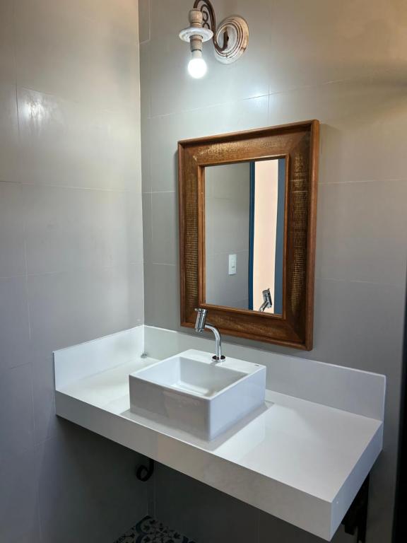 y baño con lavabo blanco y espejo. en Casa da Tuta Pousada en Tiradentes