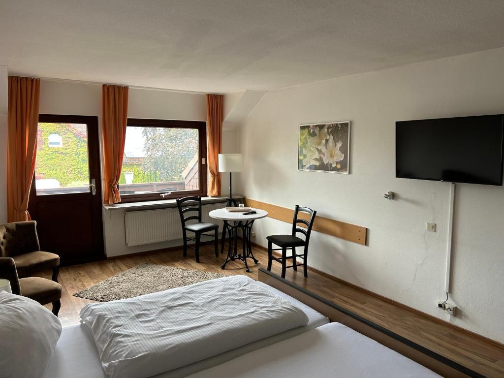 a bedroom with a bed and a table and chairs at Piets Gästezimmer in Sandstedt
