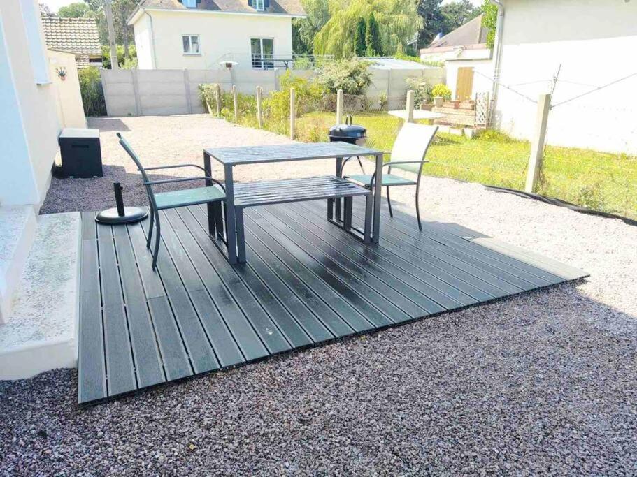 a picnic table and two chairs on a patio at « L’Hilo » Appart 4 Personnes À 250 m de la Plage in Varaville