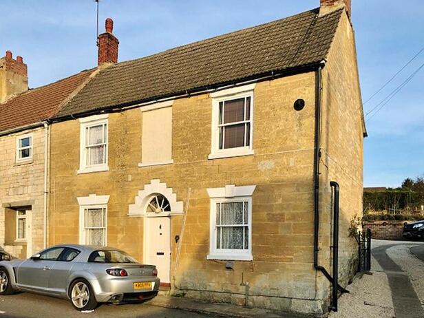 a house with a car parked in front of it at Ashley Cottage in Colsterworth