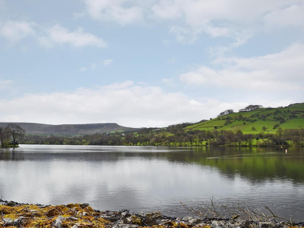 a view of a lake with hills in the background at Rose Cottage in Taxal