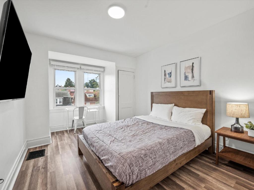 a white bedroom with a bed and a window at Oakland/University @H Bright and Stylish Private Bedroom with Shared Bathroom in Pittsburgh