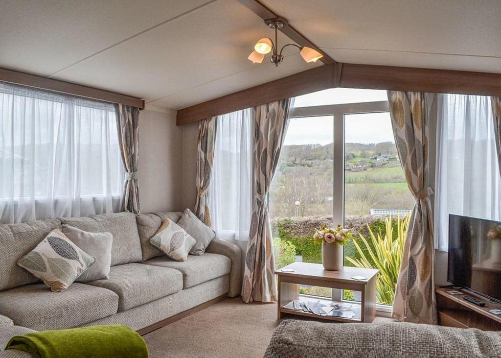 ein Wohnzimmer mit einem Sofa und einem großen Fenster in der Unterkunft Tan-y-fron Holiday Park in Dolgellau