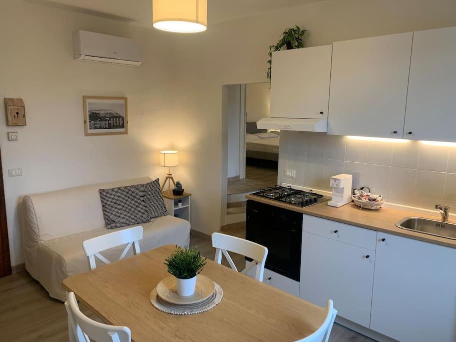 a kitchen and living room with a table and a couch at La casa di Tommy in Monsummano