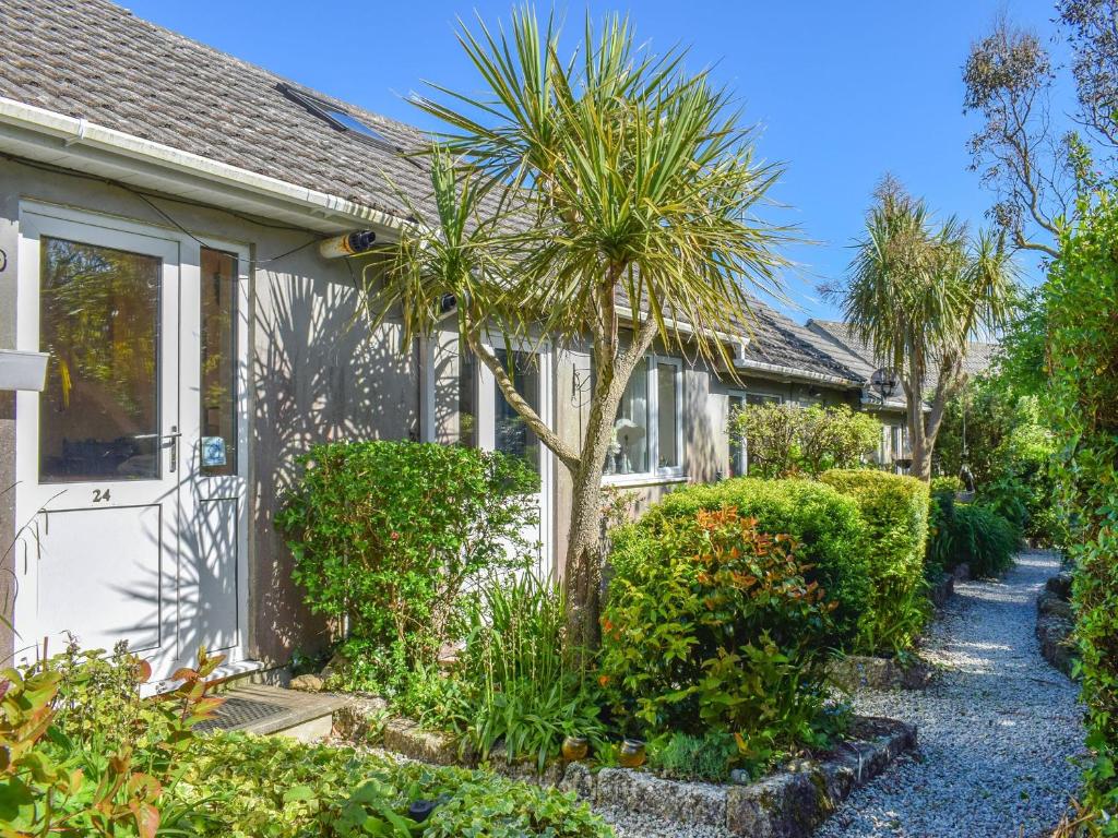 a house with a palm tree in front of it at 16 Beech Cottage-uk38936 in Porthcurno