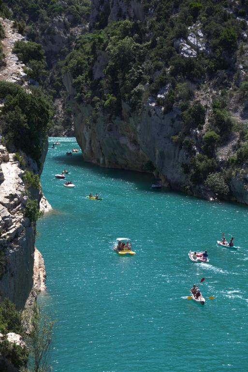 un groupe de bateaux dans une rivière près d'une montagne dans l'établissement Appartement en Provence avec possibilite garage motos et velo, à Salernes