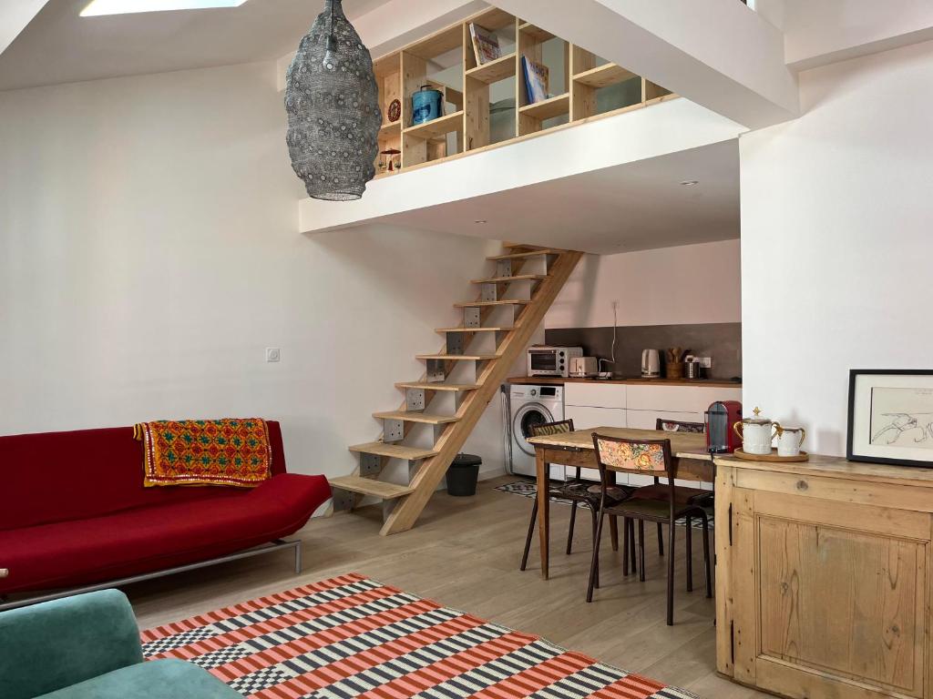 - un salon avec un canapé rouge et un escalier dans l'établissement Suite Bergame, à Caluire-et-Cuire