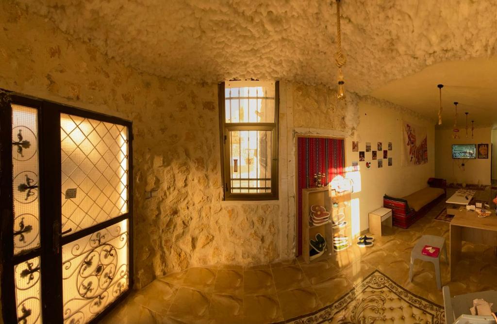 a room with a stone wall with a window at Nabati hostel in Wadi Musa