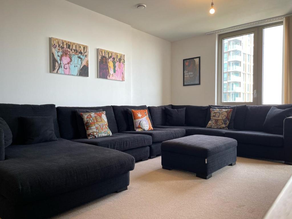sala de estar con sofá azul y taburete en Spacious Flat in Manor House, London en Londres