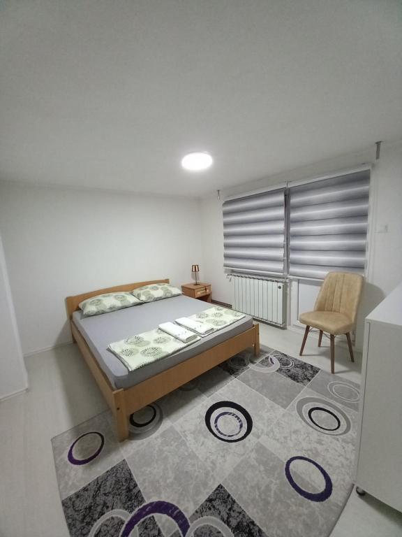 a bedroom with a bed and a chair and a rug at Apartment Maida in Dubrave Gornje