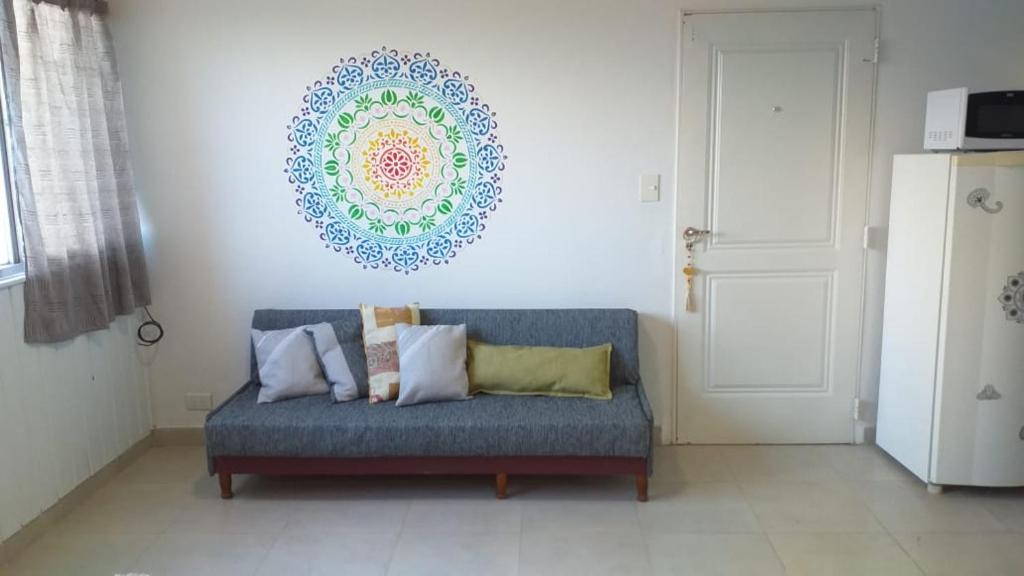 eine blaue Couch in einem Wohnzimmer mit einem Gemälde an der Wand in der Unterkunft Alquiler Temporario Shanti in Trelew