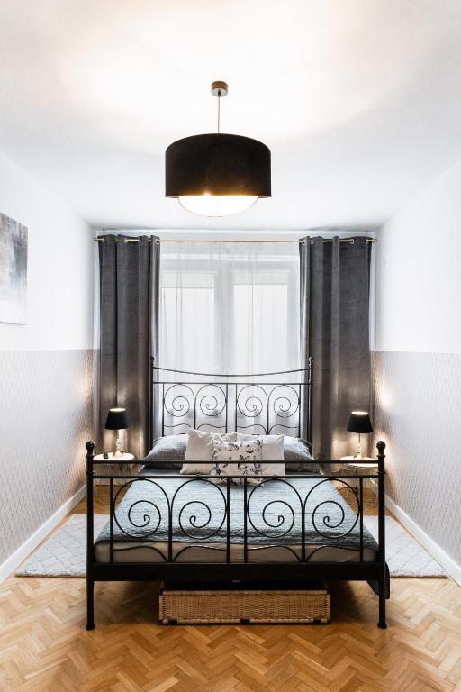 1 dormitorio con cama negra y ventana en ClickTheFlat Krucza City Center Apart Rooms, en Varsovia