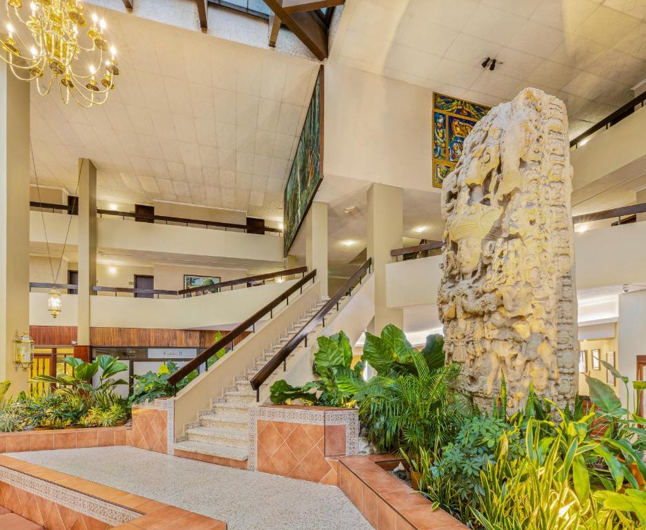 a lobby with a staircase and a large rock sculpture at Copantl Hotel & Convention Center in San Pedro Sula