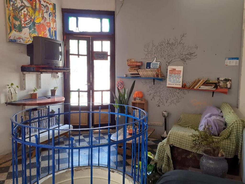 uma sala de estar com uma mesa redonda azul e um sofá em Coolraul Hostel em Rosário