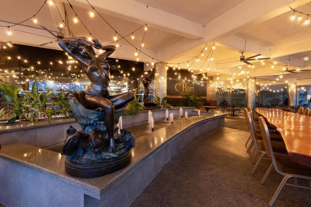 a restaurant with a statue of a woman sitting on a fountain at Copantl Hotel & Convention Center in San Pedro Sula