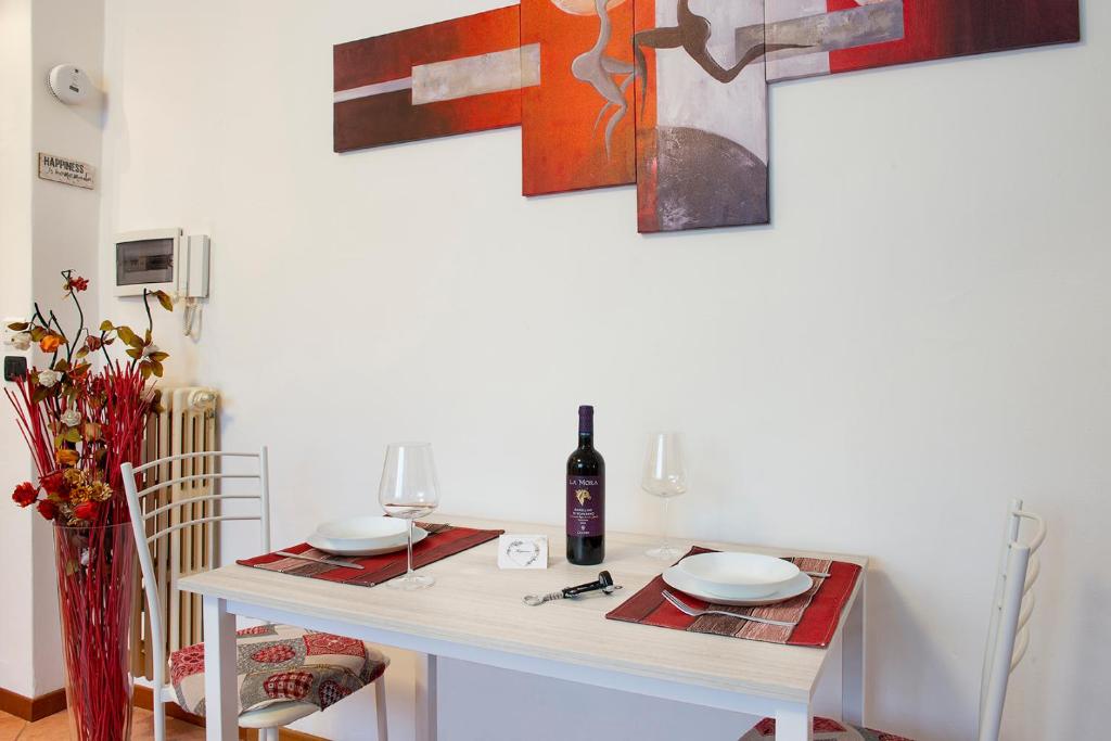 einen Tisch mit 2 Tellern und eine Flasche Wein in der Unterkunft Casa Viotti Monza in Monza