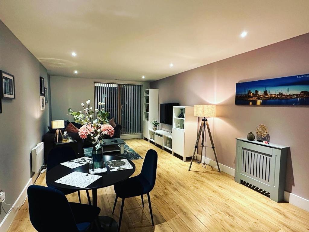 ein Wohnzimmer mit einem Tisch und Stühlen in der Unterkunft Spacious Luxury Waterfront Apartment in Ipswich