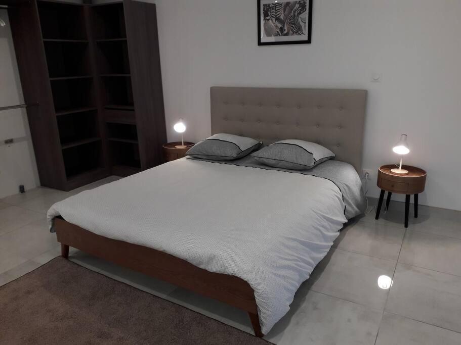 une chambre avec un grand lit avec deux tables de nuit dans l'établissement Maison neuve de standing 150 m2, à Croix-Chapeau