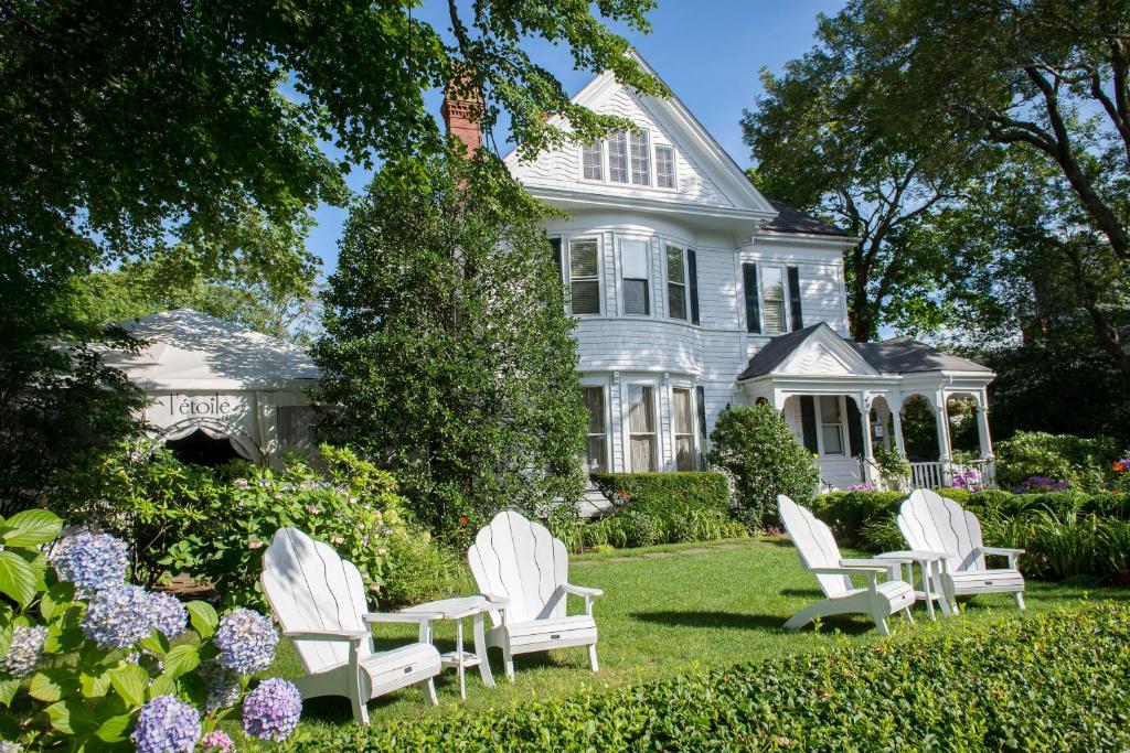 a group of white chairs in front of a house at The Coco, The Edgartown Collection in Edgartown