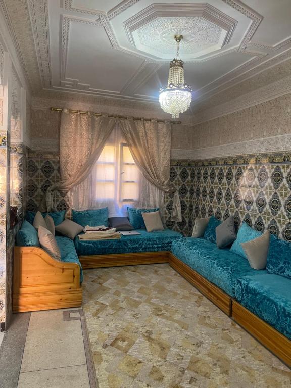 a living room with blue couches and a window at Appartement near to AirPort 262 avenue el khalij in Marrakech