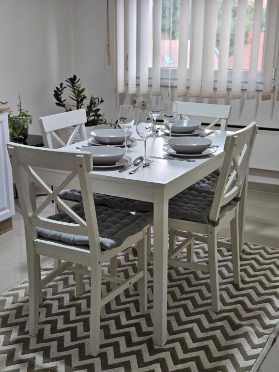 tavolo bianco con sedie e bicchieri da vino di Epicentar apartment a Loznica