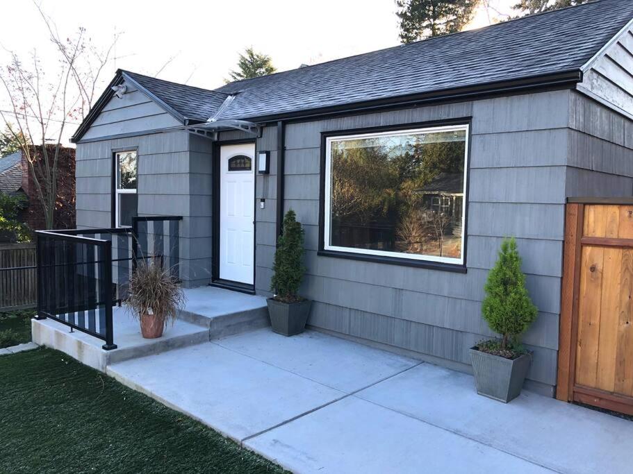 ein kleines Haus mit einer Veranda und einer Holztür in der Unterkunft Cozy Crown Hill Carkeek Cottage w/3 Beds, Full Kitchen & Backyard in North Seattle in Seattle
