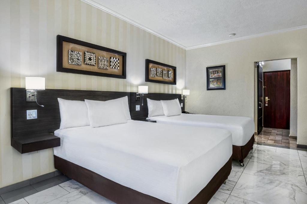 a hotel room with two beds with white pillows at Copantl Hotel & Convention Center in San Pedro Sula
