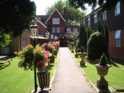 einen Gehweg in einem Hof mit Blumen und Häusern in der Unterkunft The Victoria Hotel in Canterbury