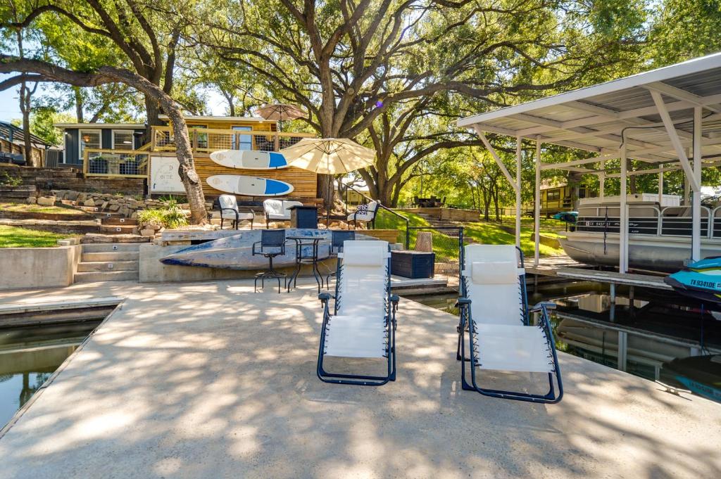 a patio with chairs and a table and a boat at Waterfront Lake LBJ Cabin with Private Dock! in Burnet