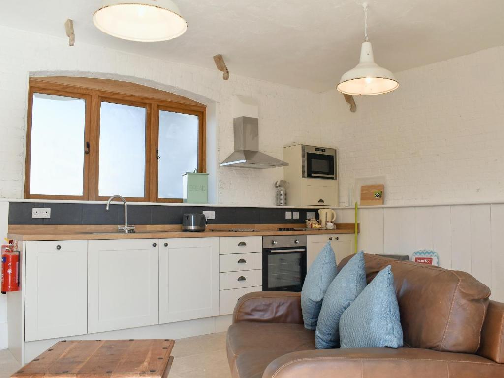 a living room with a couch and a kitchen at The Nags Stable - Ukc4136 in Arlingham