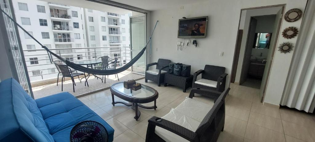 sala de estar con sofá azul y balcón en Aqualina Orange Apartamento Piso 6 Vista a Piscina 3 Habitaciones, en Girardot