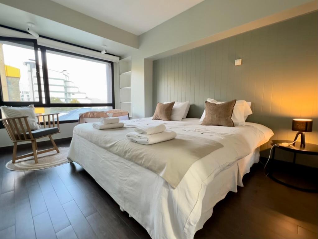 ein Schlafzimmer mit einem großen Bett mit Handtüchern darauf in der Unterkunft Seaport Apartments Rivadavia I in Ushuaia