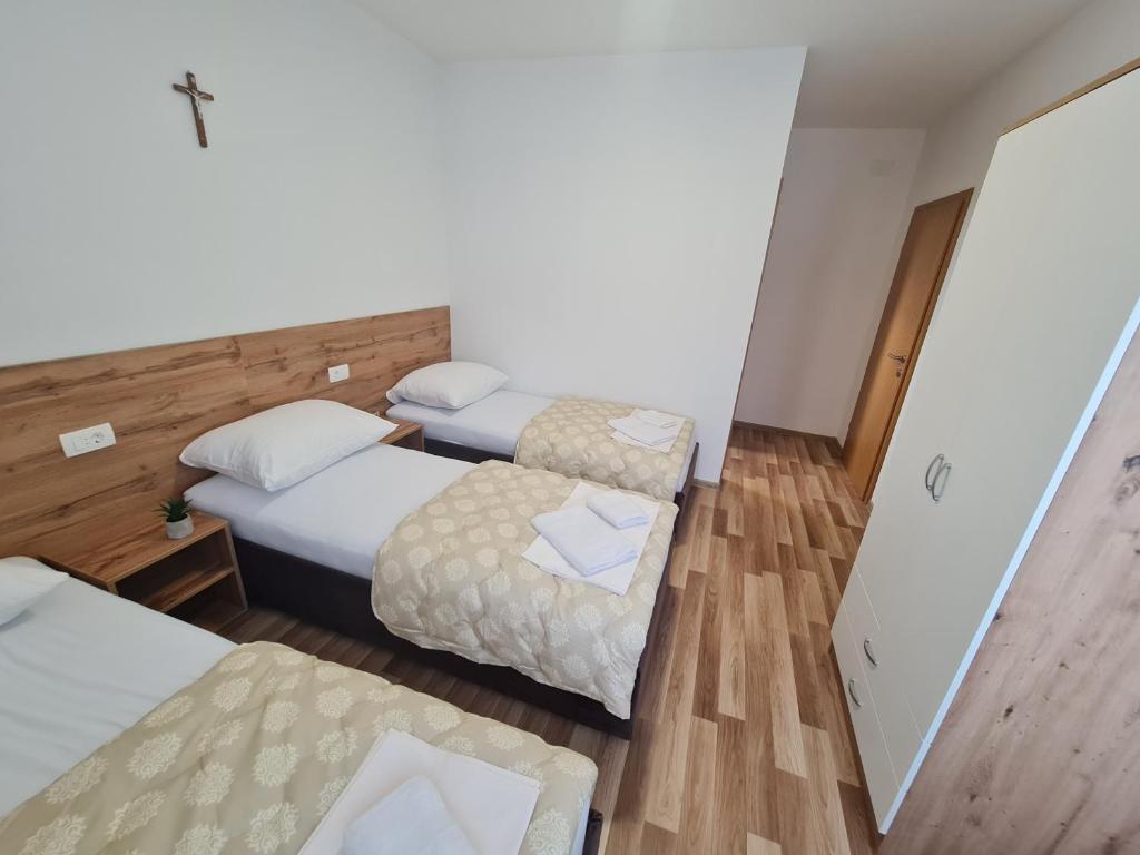 a hotel room with two beds and a table at Pansion Vesna&Vlado Ostojic in Međugorje